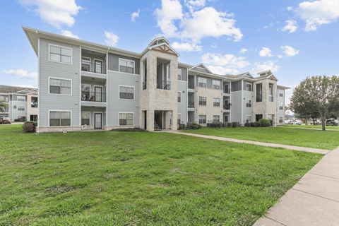 A large apartment complex with multiple buildings and green lawns.