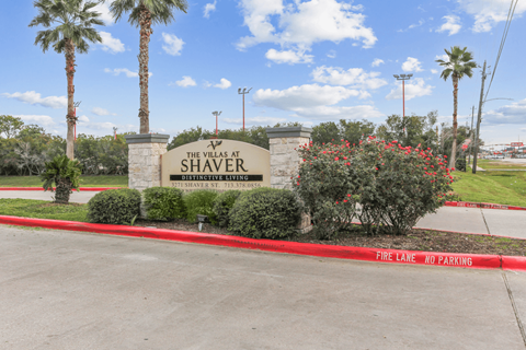 The Villas at Shaver Distinctive Living sign with a red fire lane no parking strip.