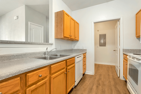 A kitchen with wooden cabinets and a white sink.