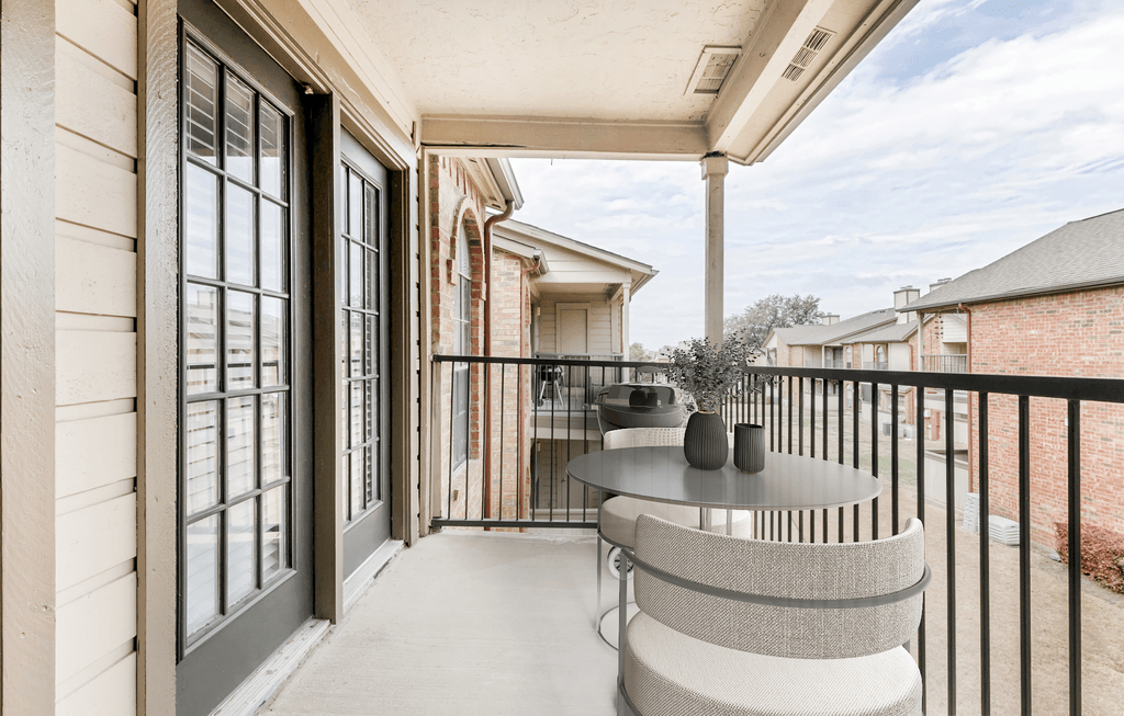 Virtually staged covered balcony with round table and chairs with metal banister