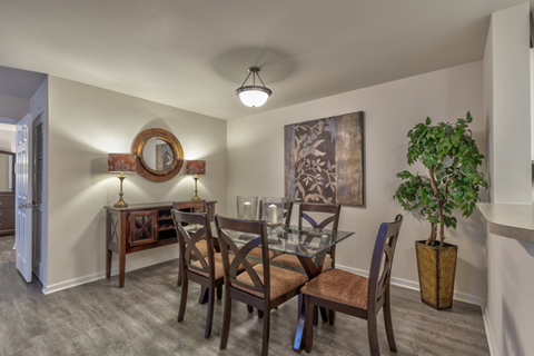 A dining room with a glass table and chairs.