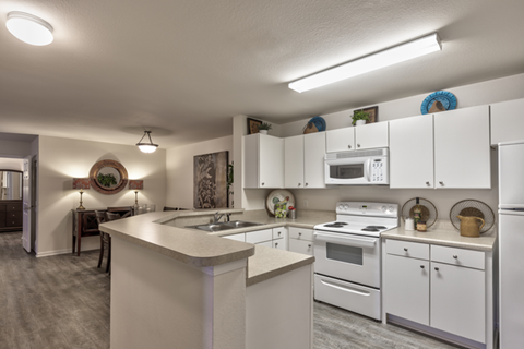 A kitchen with white cabinets and appliances.