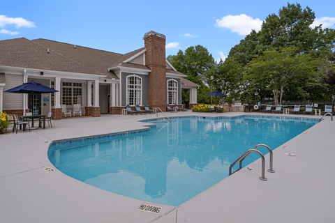 A pool with a brick building behind it.