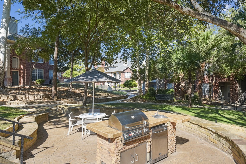 A backyard with a BBQ grill and patio furniture.