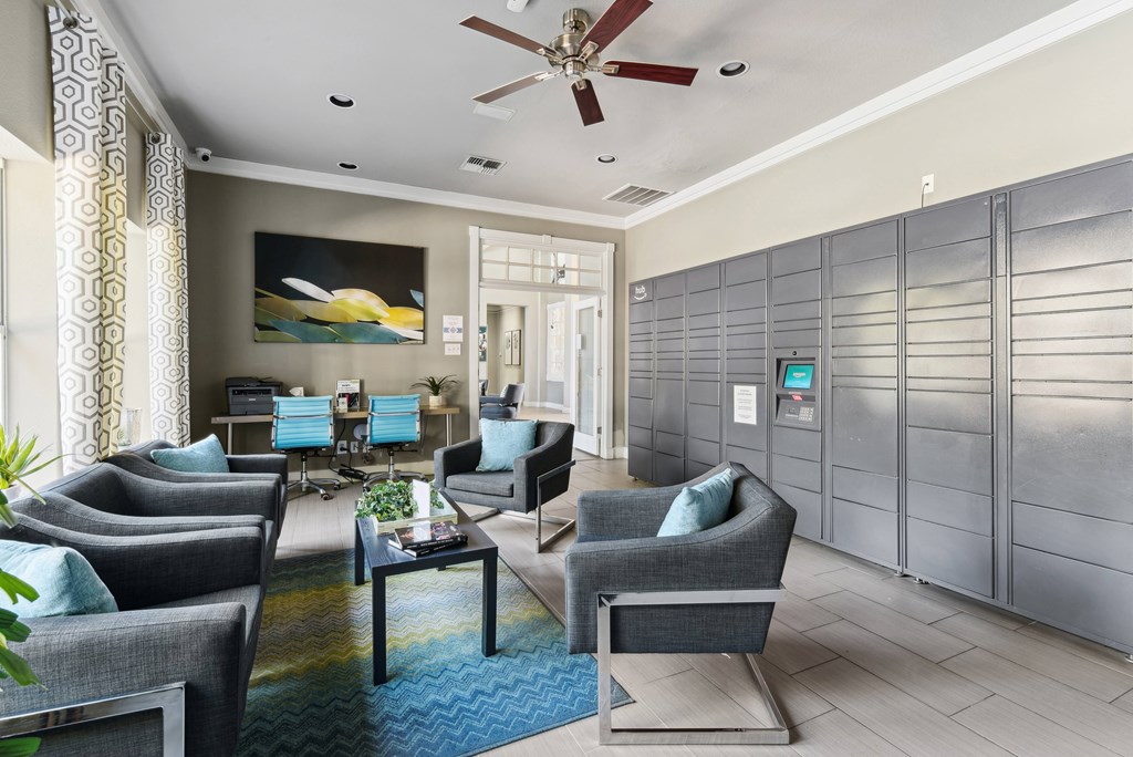 A modern waiting room with grey chairs and a ceiling fan.