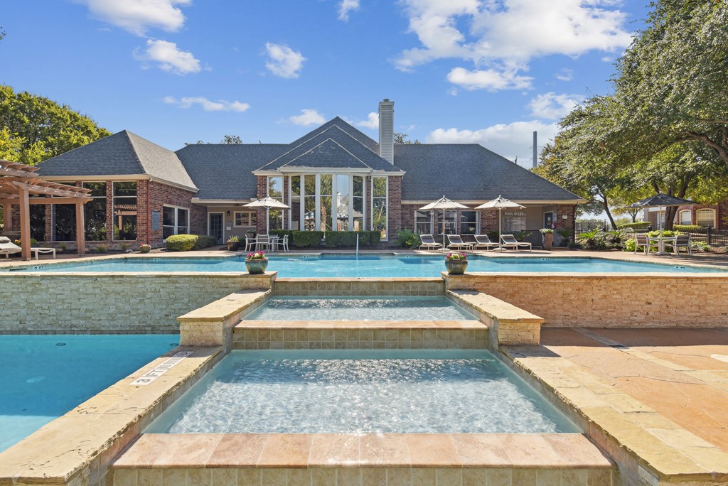 A house with a pool and a waterfall in front.