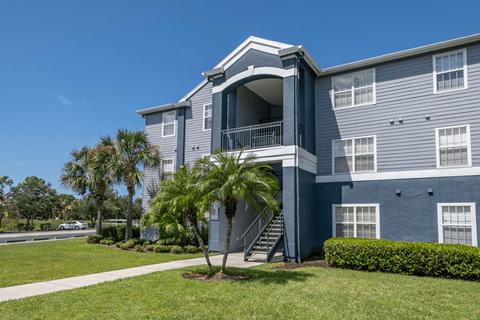 Blue apartment building with staircase leading to the 2nd floor.