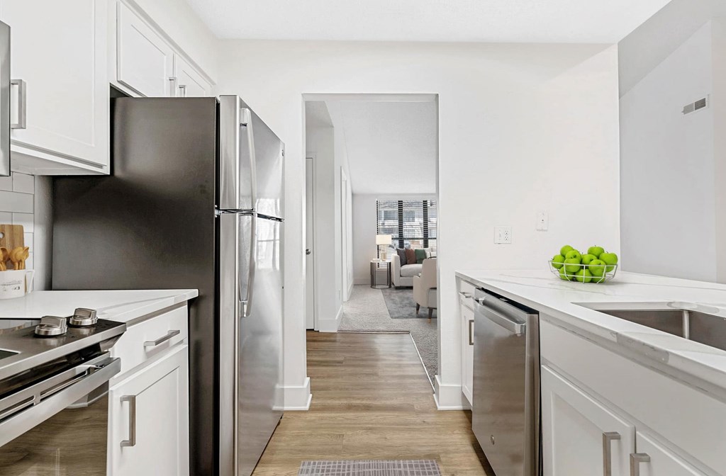 A kitchen with a black refrigerator and white cabinets. at Woodlyn on the Green Apartment Homes, Cary, NC
