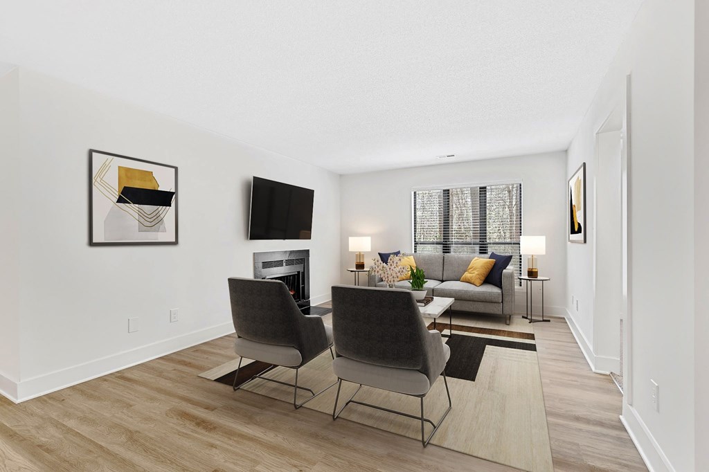 A living room with a grey couch, two chairs and a fireplace. at Woodlyn on the Green Apartment Homes, North Carolina, 27513