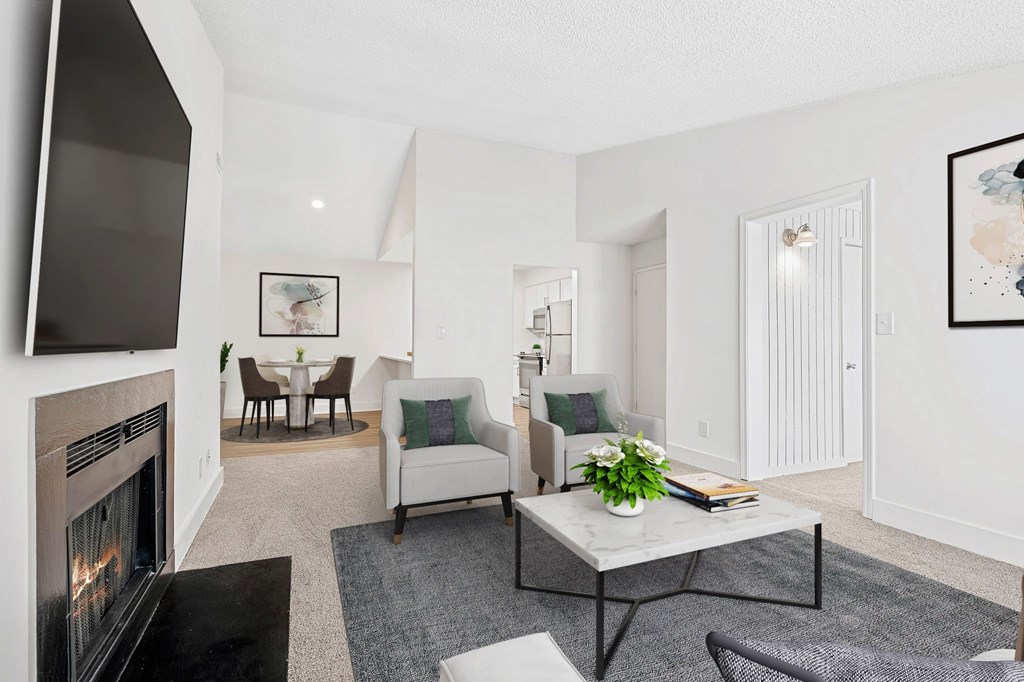 A living room with a fireplace and a couch. at Woodlyn on the Green Apartment Homes, Cary, 27513