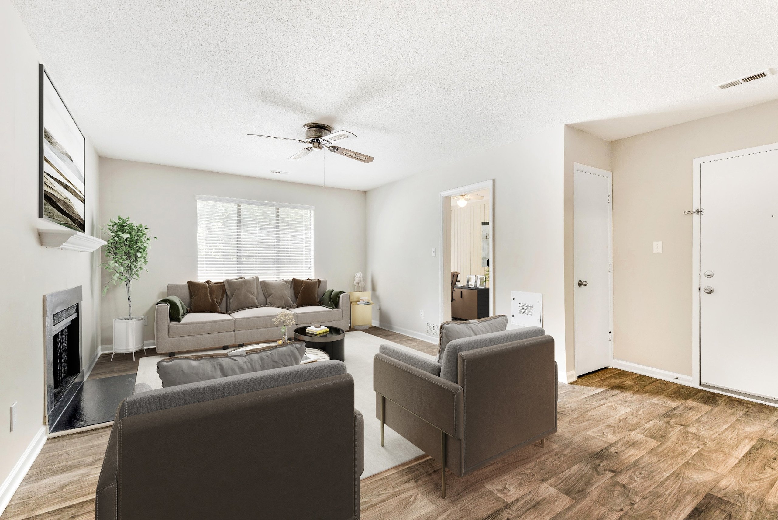 A living room with a grey couch and a fireplace.