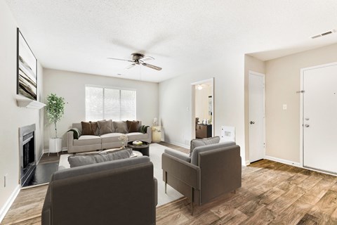 A living room with a grey couch and a fireplace.