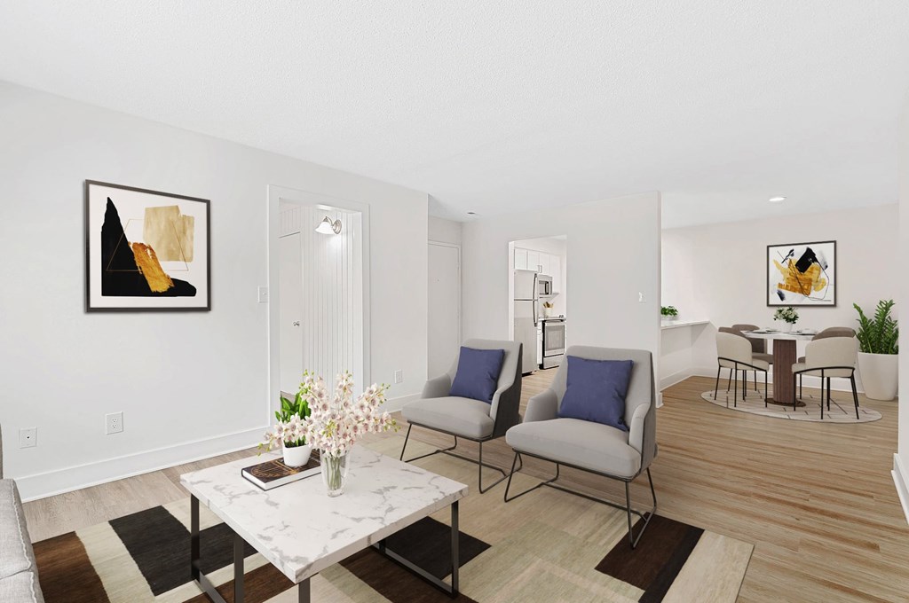 A living room with a white marble table and two grey chairs. at Woodlyn on the Green Apartment Homes, Cary, North Carolina