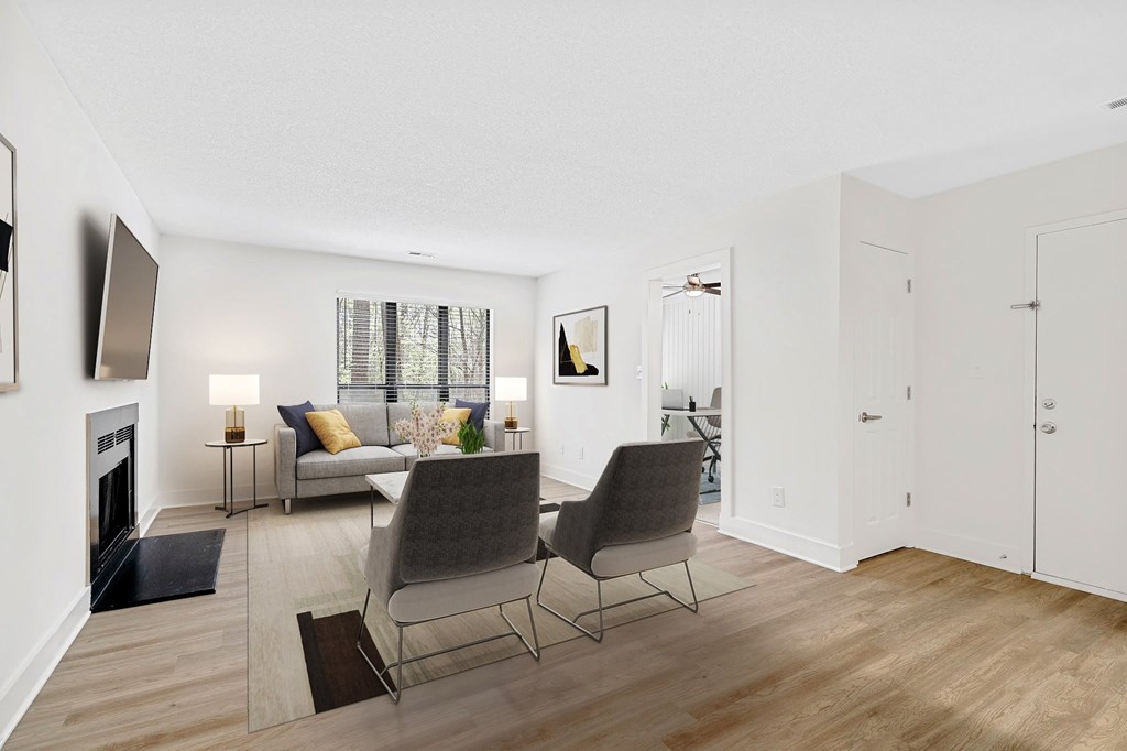 A living room with a fireplace and two chairs. at Woodlyn on the Green Apartment Homes, Cary, NC