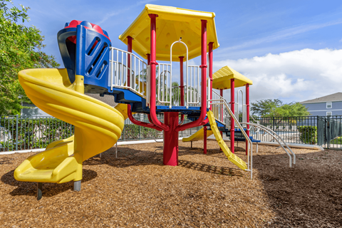 a playground with a yellow slide and a red and blue slide