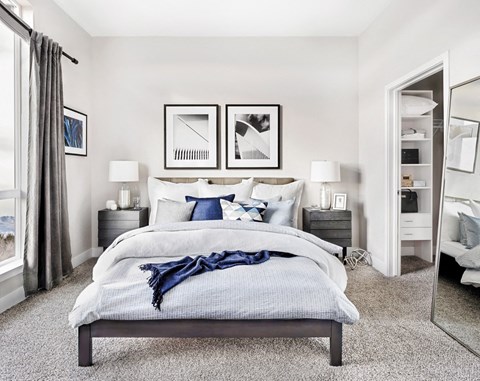 A bedroom with a large bed and a mirror on the wall.