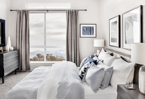 A bedroom with a large bed and a window overlooking the mountains.