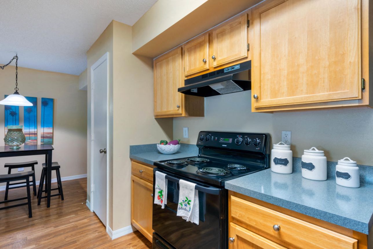 A kitchen with wooden cabinets and a black stove top.