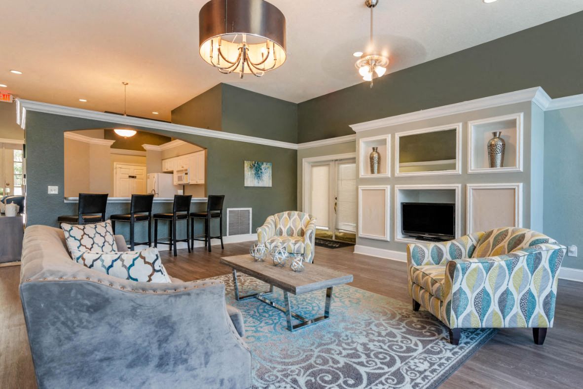 A living room with a grey couch and a patterned armchair.