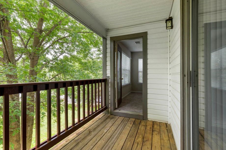Balcony with Wooden Floor and Brown Railing and View of Treetops