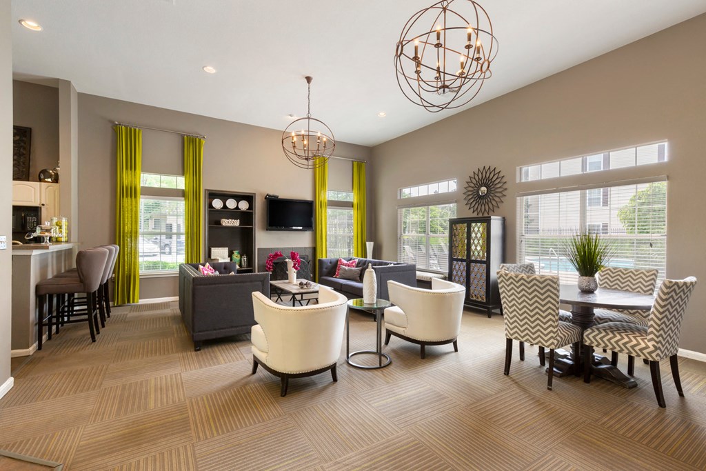 Clubhouse with Contemporary Fixtures and Decorations and Dining Table with Chevron Print Chairs Next to White Armchairs