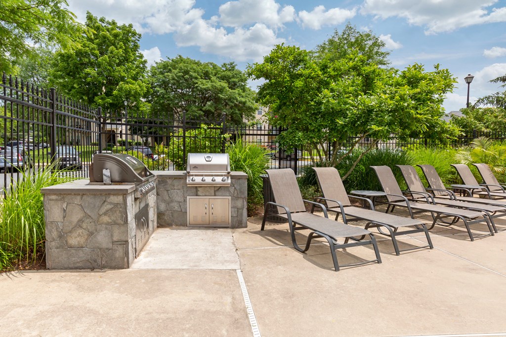 Sundeck with lounge chairs, and stone outdoor grilling area