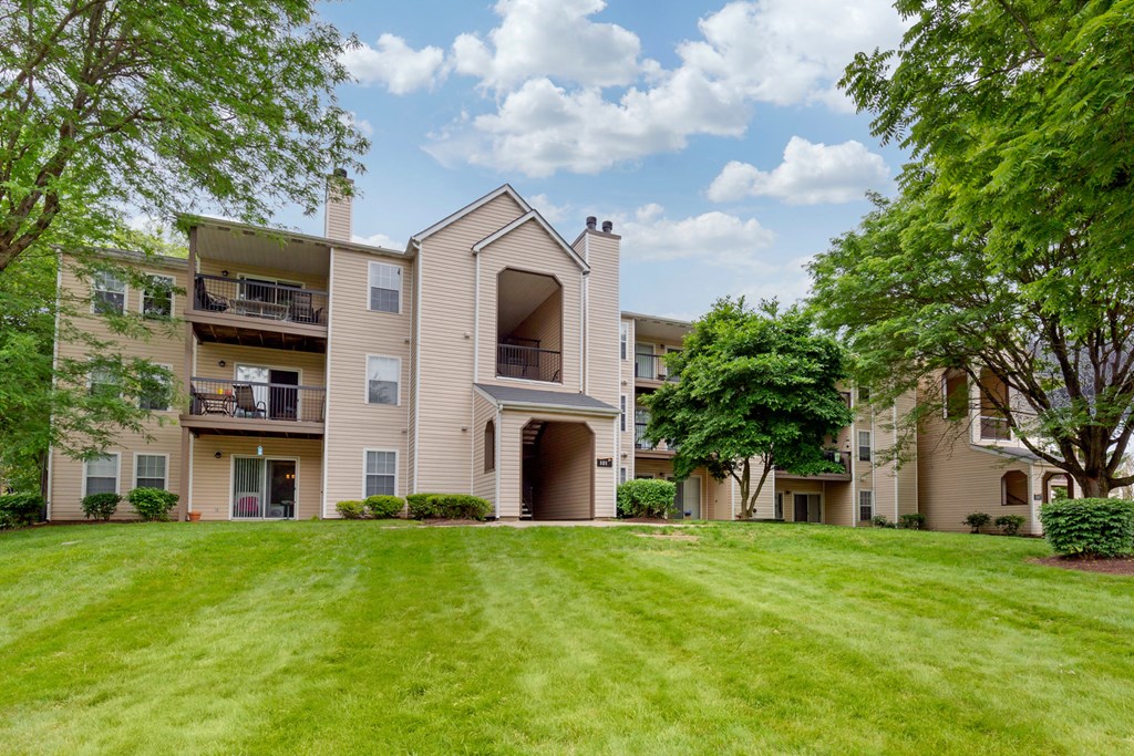 Exterior building with large green grass area and mature trees