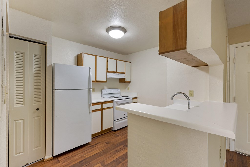 a kitchen with a white counter top and white appliances