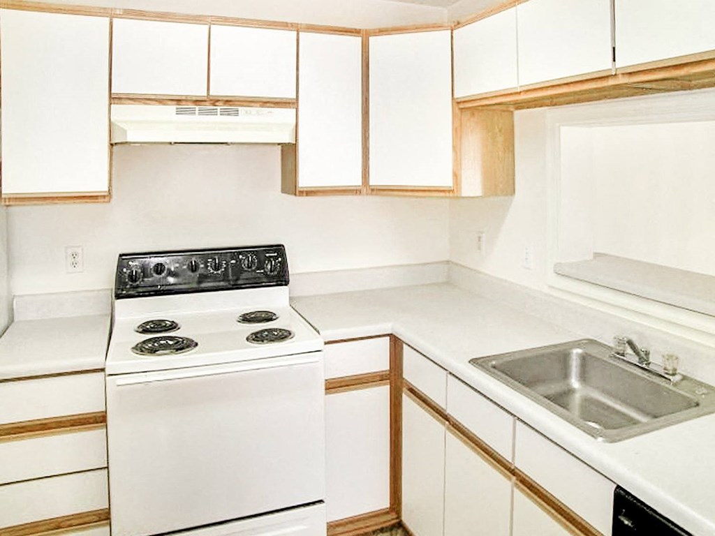 White cabinets and appliances with hardwood style flooring