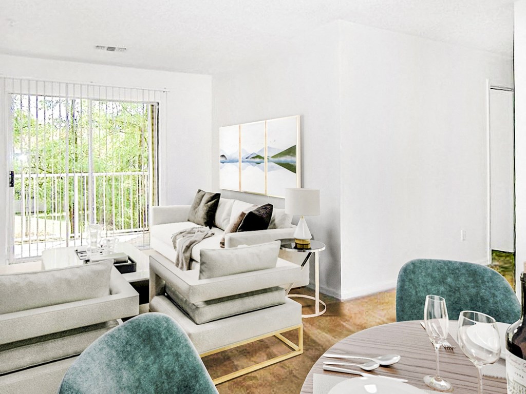 Carpeting living room with white walls, art above the couch, and table and chair set