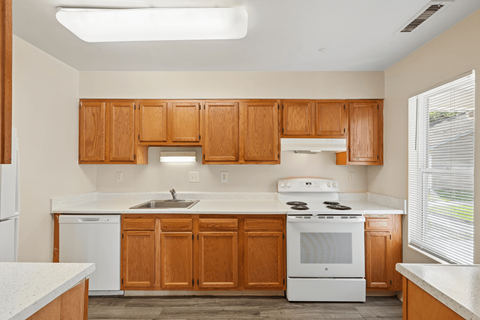 A kitchen with wooden cabinets and white appliances.