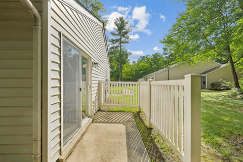 apartment patio with a white fence