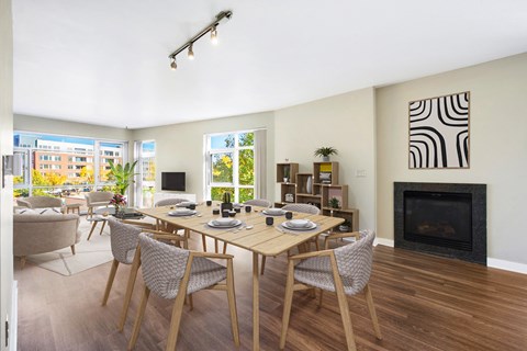 A dining room with a table set for six with a fireplace and a zebra print picture on the wall.