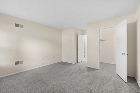 A room with a carpeted floor and white walls.