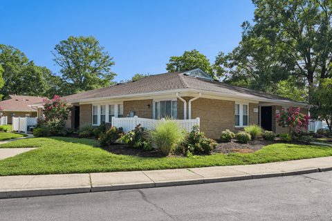 A house with a white picket fence and a green lawn.