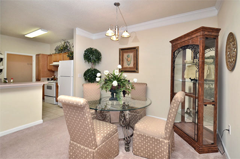 Dining area adjacent to kitchen and living room. A circular table with four surrounding chairs is in the middle of the room.