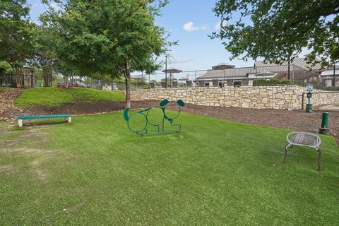 A park with a green lawn and a playground.