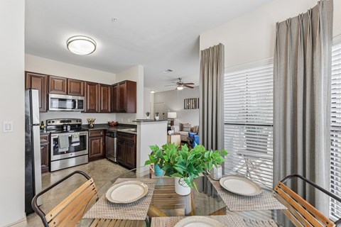 A modern kitchen with a dining table set for two.