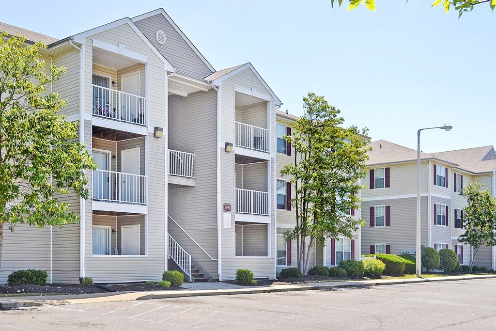 Building Exterior surrounded by shrubbery and trees with view of parking lot