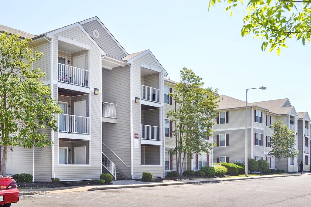 Building Exterior surrounded by shrubbery and trees with view of parking lot