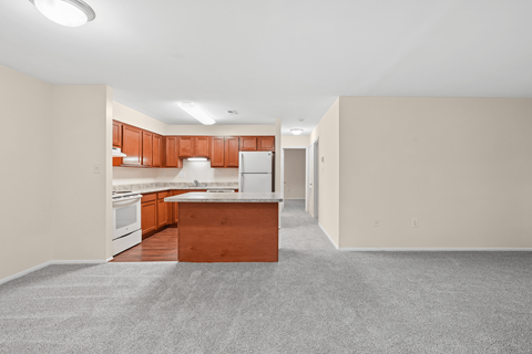 A kitchen with a white fridge and wooden cabinets.