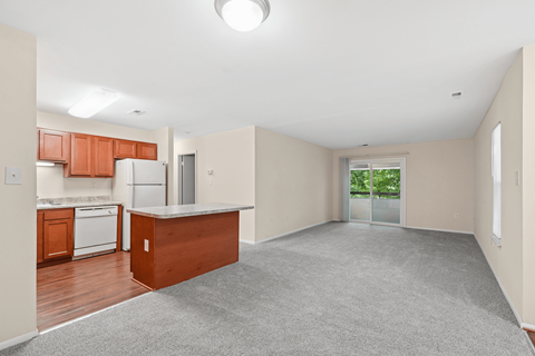 A spacious kitchen with wooden cabinets and a white refrigerator.