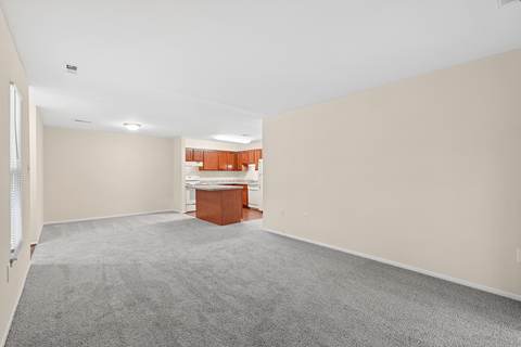 A room with a grey carpet and a white ceiling.