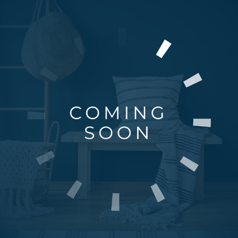 A room with a chair, a sofa, and a lamp with a "Coming Soon" sign.
