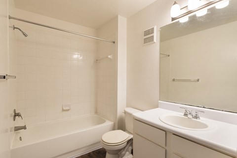 A white bathroom with a toilet, sink, and bathtub.