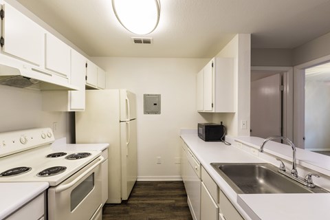 A kitchen with white appliances and cabinets.
