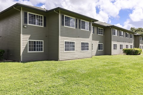 A row of apartments with grass in front.