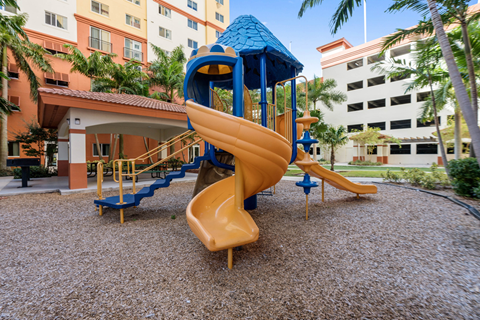 A playground with a blue roofed slide and a yellow slide.