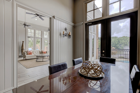 a dining area with a wooden table and black leather chairs