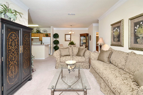 A living room with a beige couch and a coffee table.